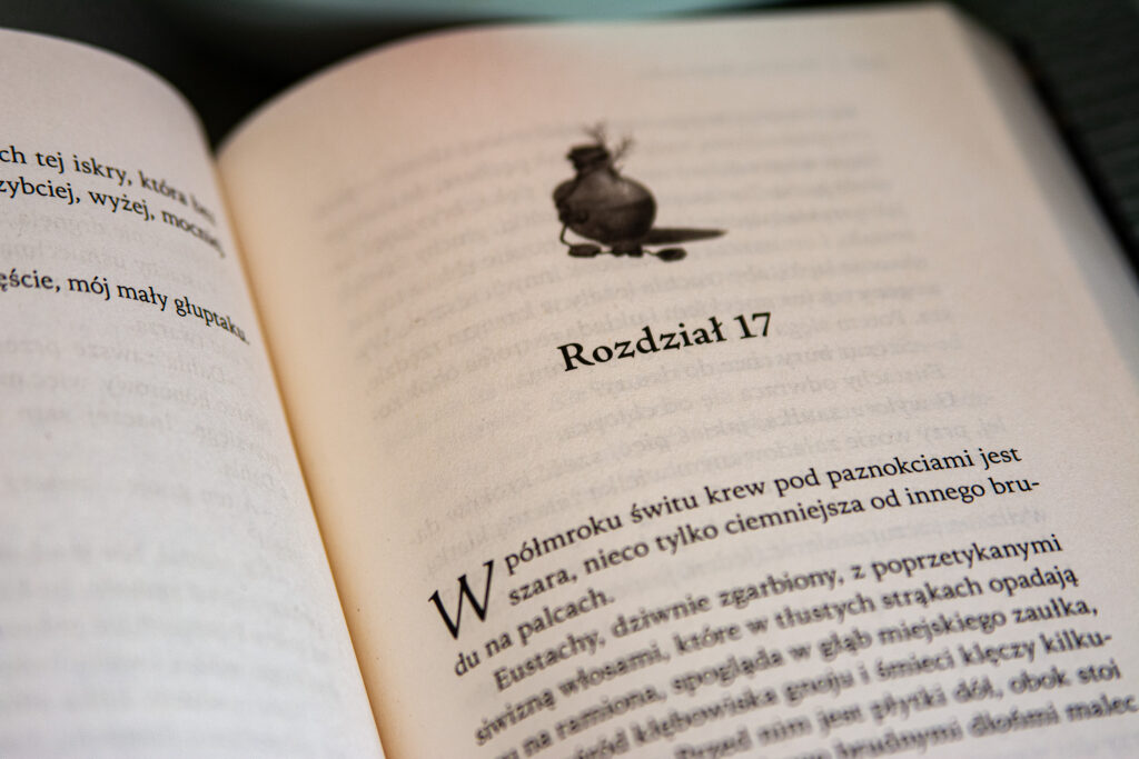 Więcej niż zło Eweliny Stefańskiej - książka otwarta na rozdziale 17 leży na blacie stołu - ilustracja do recenzji